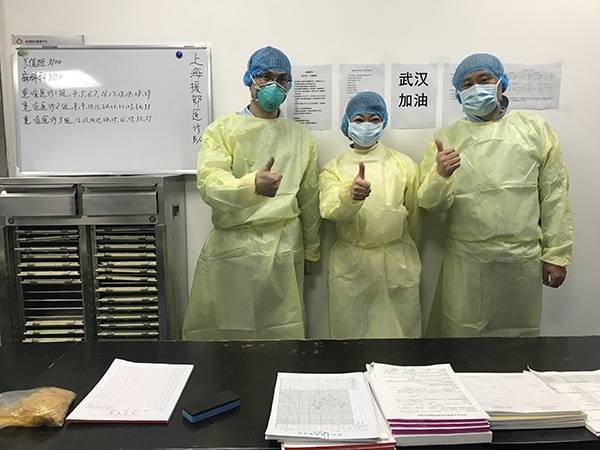 上海市六医院金山分院呼吸内科副主任医师徐浩（右一）在武汉金银潭医院重症监护室与战友们在一起。