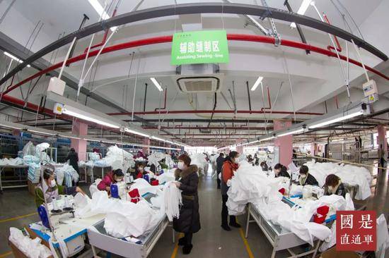 2020年2月18日，在泰州市舜光服饰有限公司工人们在生产隔离服。中新社发汤德宏摄