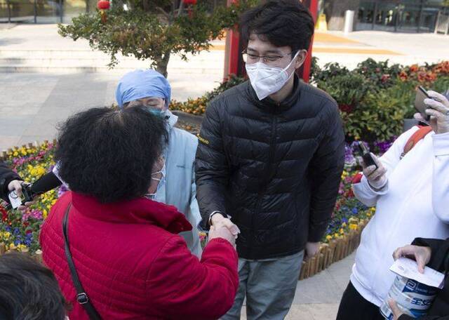 治愈患者（左红衣者）感谢北京医疗队队员。