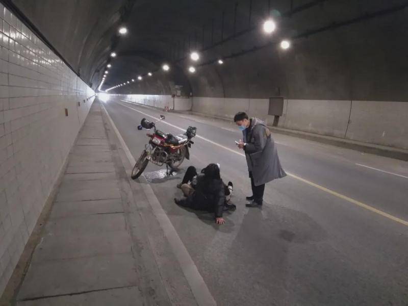 隧道内夫妻俩躺倒在路旁，他果断将车停到后方50米……