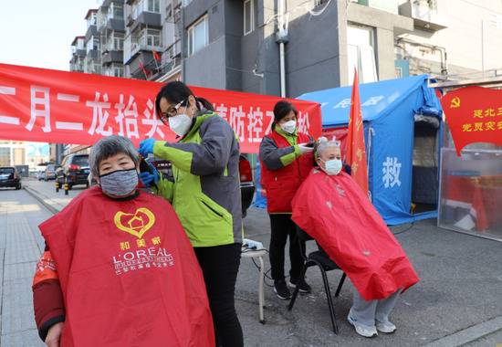 ▲资料图。图为一社区为老年志愿者支起理发摊。图/新京报网