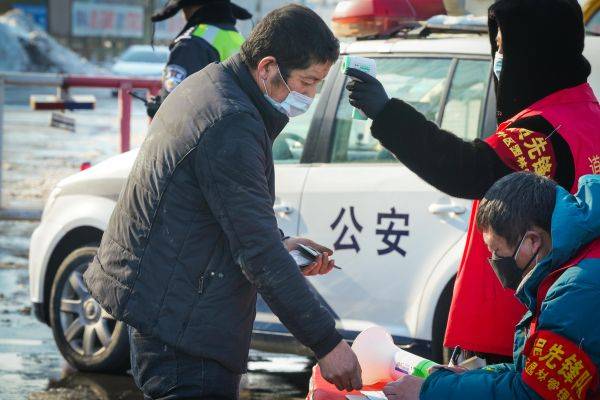 资料图片：2月24日，工作人员在哈同高速公路哈尔滨收费站为车辆人员登记、测体温。（新华社）