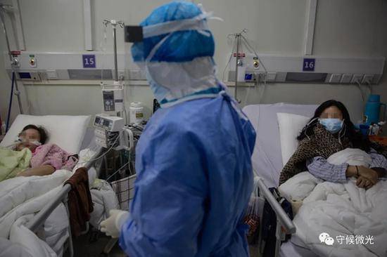 2月21日，武汉火神山医院感染八科，医护人员在病房内了解患者的情况。中青报·中青网记者李峥苨/摄