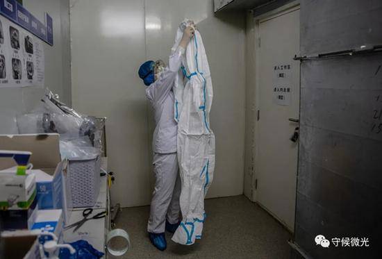 2月21日，武汉火神山医院感染八科，一名医护人员准备穿上防护服进入病区。为了防止污染，防护服不能着地，穿着过程中需时刻注意。中青报·中青网记者李峥苨/摄