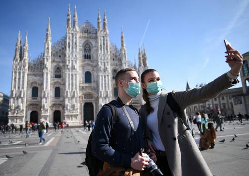 2月24日，在意大利米兰，人们戴着口罩在大教堂前自拍。新华社发