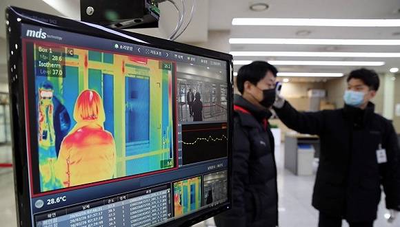 2月26日，韩国国会大楼对来往人员进行测温。图片来源：Yonhap