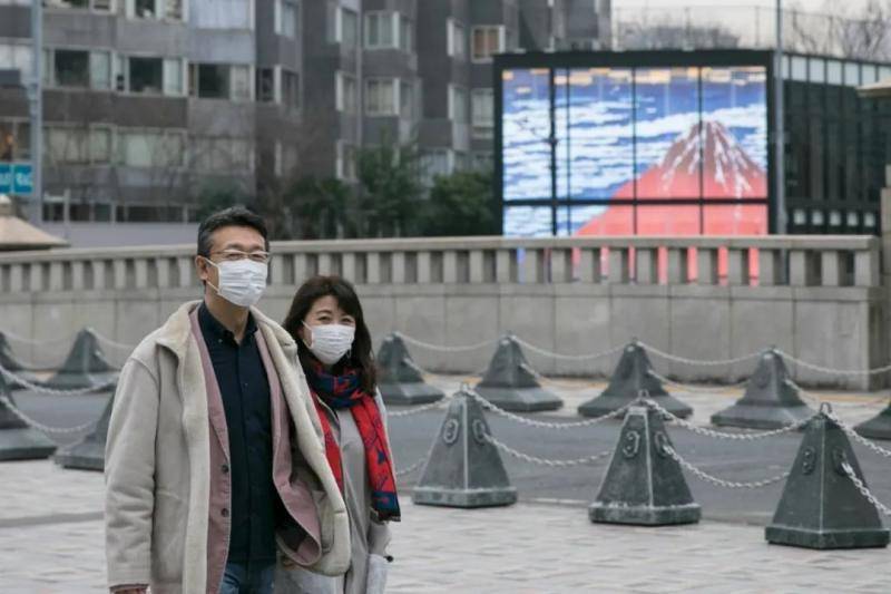  2月25日，在日本东京，人们戴口罩出行。