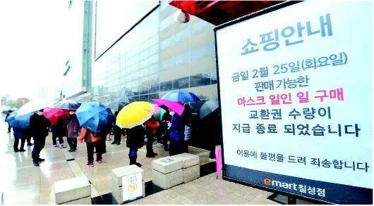 韩国大邱，居民在雨中排队购买口罩，超市告示每人当日限购一只口罩。来源：新华社