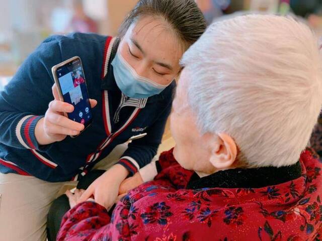 西钓鱼台一养老院，护理员帮助老人通过视频通话方式与家属联络。受访者供图