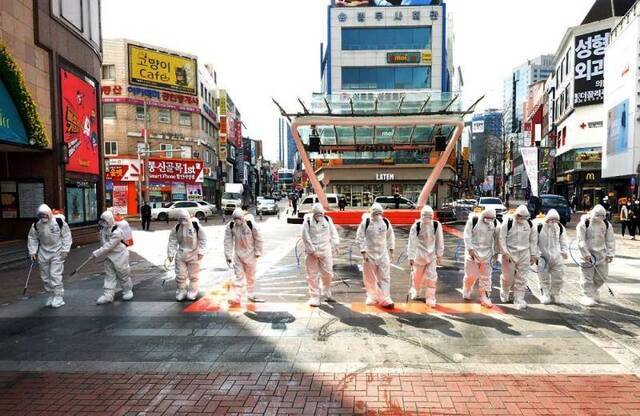  2月27日，在韩国大邱，士兵身着防护服在街头进行消毒工作。新华社/美联