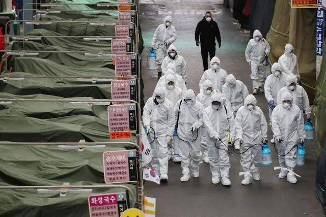 △在韩国大邱，工作人员在一家市场内进行消毒工作。