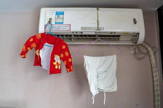 一家人蜗居的武汉酒店房间，悬挂着小康康的衣服。