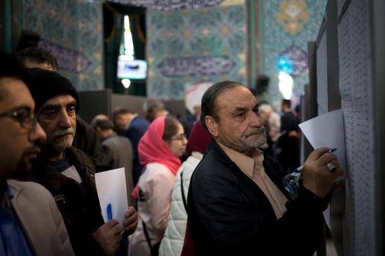 2月21日，在伊朗首都德黑兰，人们在一处投票站参加议会选举投票
