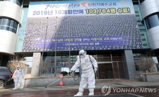 “新天地”大邱教会前，工作人员消毒防疫。图源：韩联社