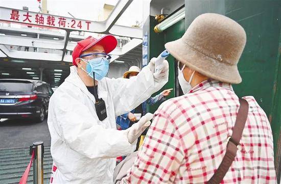 △2月28日，海口秀英港码头的工作人员正对过海离岛旅客进行体温测量、身份核验等工作