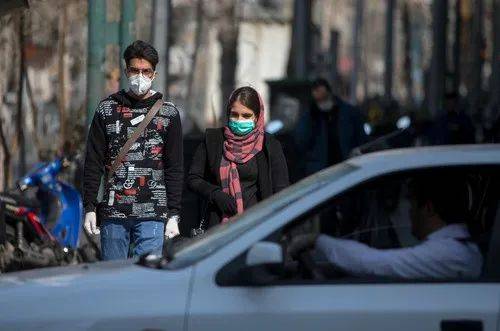 2月23日，在伊朗首都德黑兰，市民戴着口罩出行。新华社发