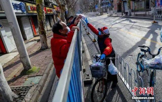 2月29日，武汉江岸区永清街吉林社区志愿者苏仁鹏给居民送药。中新社记者张畅摄