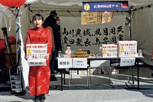 2月8日，在日本东京池袋，“旗袍女孩”在“东京灯会满月祭”现场为中国募捐。图/新华