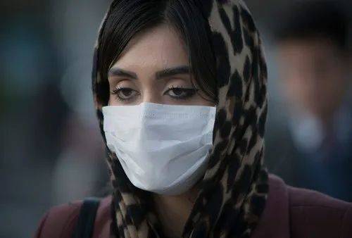 3月2日，在伊朗德黑兰，一名女子戴着口罩出行。新华社发