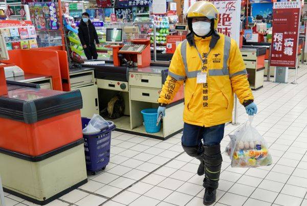 外卖小哥来到南京油坊桥附近的一家超市，帮顾客取菜。（2月19日摄）。新华社发