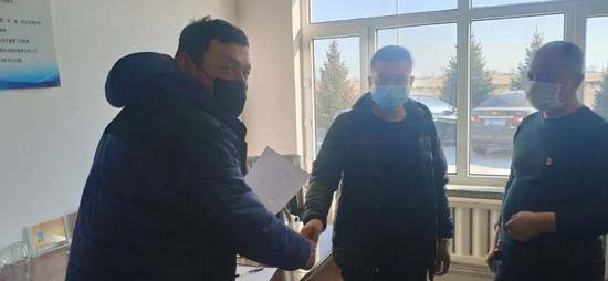 张旭（左）从青山村村委会拿到了转场通行证。
