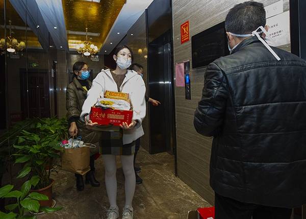 新余市中医院的护士胡曾媛与同事们提着大包小包，将生活用品搬进酒店。