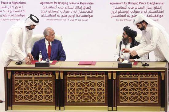 2月29日，在卡塔尔首都多哈，美国阿富汗事务特使扎尔梅·哈利勒扎德（左二）和阿富汗塔利班创始人之一毛拉阿卜杜勒·加尼·巴拉达尔（右二）参加和平协议签署仪式。图/美联