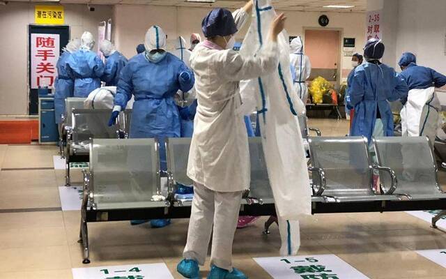 2月18日，武汉市第一医院，经过改造之后，医护人员在缓冲区穿戴防护设备。新京报向凯摄