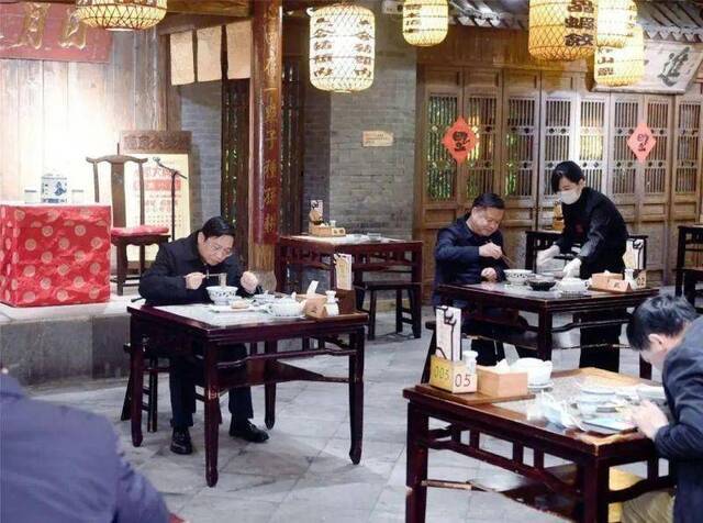 张敬华（左）来到南京大牌档，出示绿色的“苏康码”后入店就座，品尝鸭血粉丝汤等小吃。图据《南京日报》
