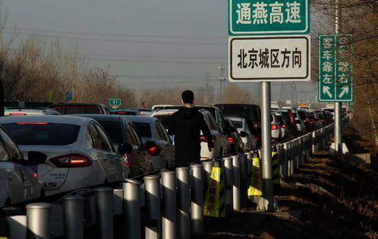 通燕高速进京方向，一位行人沿着机动车道行走。