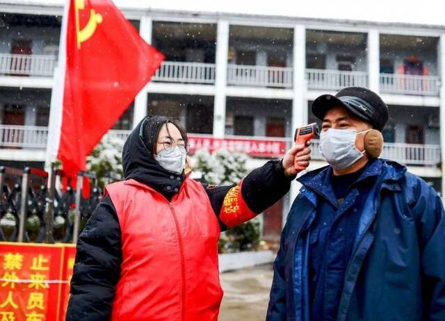 社区工作者为住户测量体温