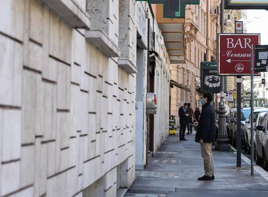  3月12日，在罗马，一名戴口罩的男子在药店外排队。新华社记者程婷婷摄
