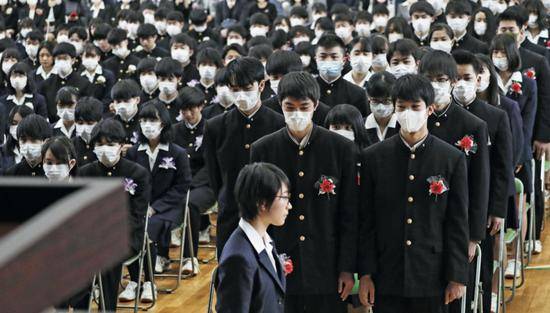 3月2日，在日本名古屋的一所高中，学生们戴着口罩参加毕业典礼。