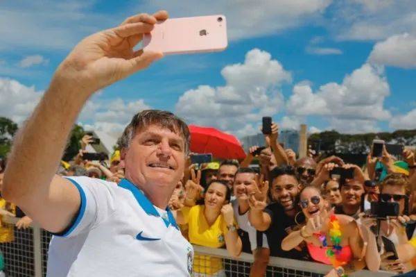 ▲博索纳罗15日在巴西利亚的游行中与支持者自拍合影。（法新社）