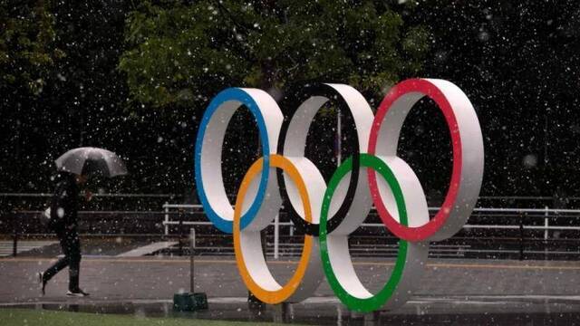 Snow falls on the Olympic rings near the New National Stadium， Tokyo， March 14， 2020。/AP