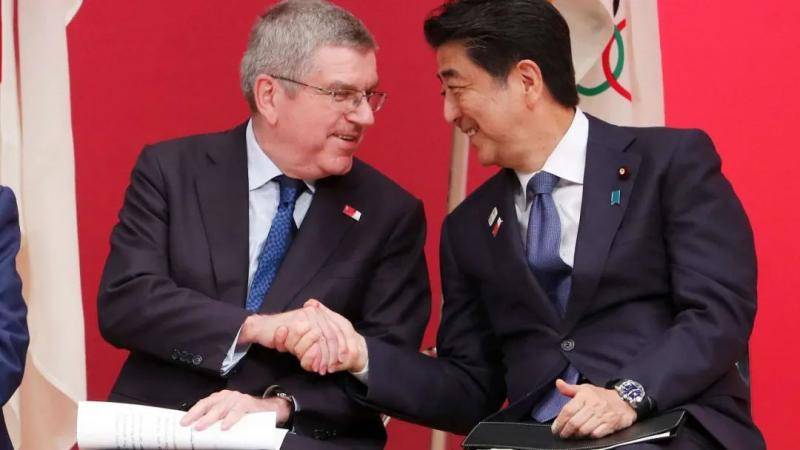  IOC President Thomas Bach（l） shakes hands with Japanese Prime Minister Shinzo Abe during the“One Year to Go Olympic Ceremony Event，” Tokyo， July 24， 2019。/AP