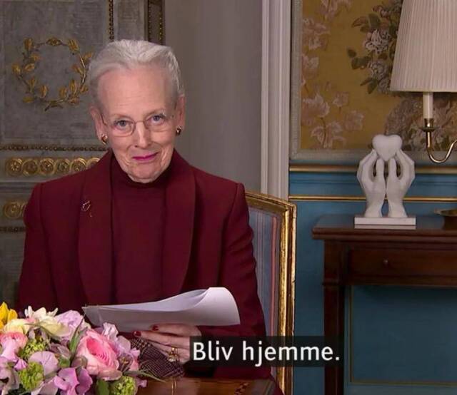 丹麦女王玛格丽特二世电视讲话截屏。字幕上这句话意为“留在家里”。