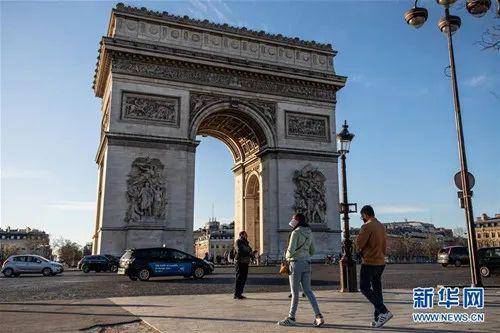 3月15日，在法国巴黎，人们走过凯旋门。