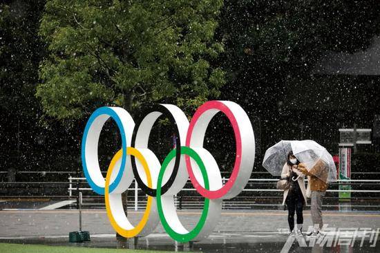 3月14日，日本东京，行人在雪中经过新国立竞技场附近的五环标志