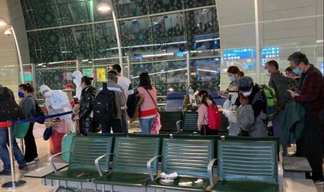 在迪拜转机时，机场有的旅客穿上了防护服。/受访者供图