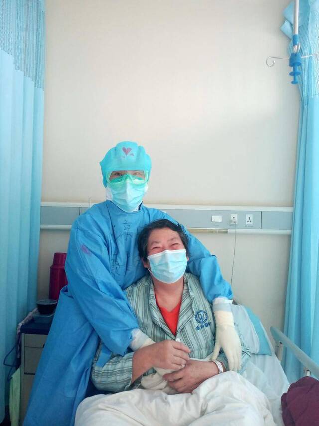 支援武汉的北京中医医院护士蔡卫敏，和患者在一起。受访者供图