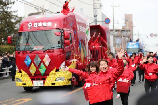 2月15日，东京奥组委举行火炬接力彩排，赞助商日本生命公司的庆祝队伍在火炬接力彩排中与观众互动