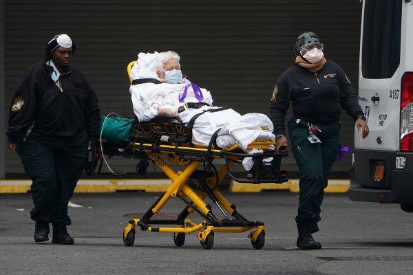 资料图片：纽约医护人员3月25日将一名患者送往医院。（路透社）