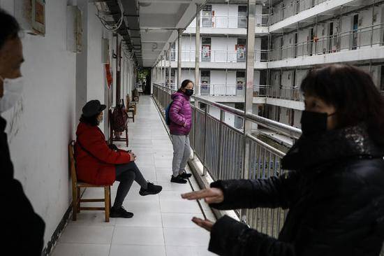3月27日，武汉软件工程职业学院康复驿站，几名结束康复隔离的观察者在等待乘车离开。他们被送至集中枢纽点后，由社区派车接至家中。中青报·中青网记者赵迪/摄