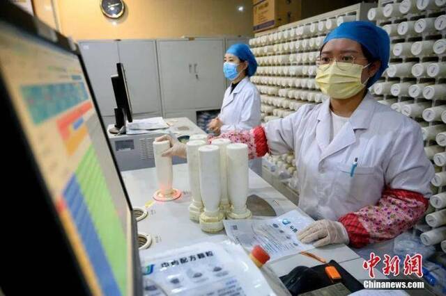3月24日，山西省太原市，医务人员使用机器调配中医药剂。这些药品经装箱后将发往海外，助力侨胞抗击疫情。中新社记者韦亮摄