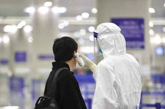 海关卫生防疫人员在为入境旅客检测体温（图源：文汇报）