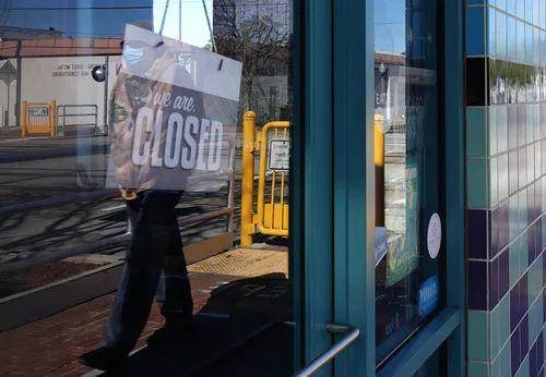 4月2日，在美国加州旧金山湾区圣马特奥市，一名男子的身影反射在一家停业店铺的玻璃上。新华社记者吴晓凌摄