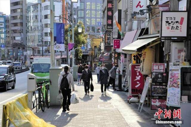 近日，随着日本东京新冠肺炎确诊人数增加，民众减少外出。图为东京戴口罩出行的民众。中新社记者吕少威摄