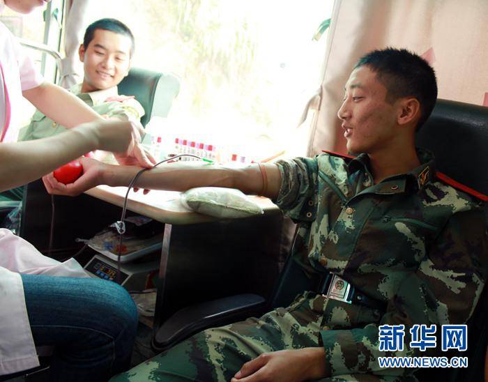 在武警江西总队赣州支队宁都中队服役时的李超(右)与战友们一起参加献血(2009年9月30日摄)。新华社发(李斌摄)