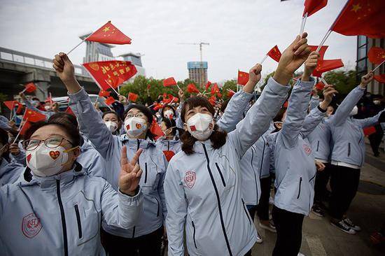 医疗队员们挥舞国旗，向武汉市民道别。